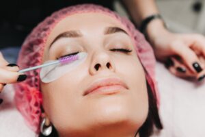 Eyelash treatment in Auburn, AL spa, woman relaxing during beauty procedure with attention to detail.