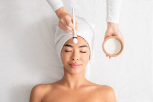 Facial treatment in Auburn, AL. Relaxing spa session with face mask on a serene woman.