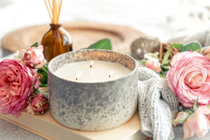 Elegant lit candle with roses on a table, Auburn, AL. Cozy ambiance perfect for relaxation and decor.