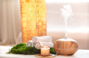 Cozy spa setup with towels, candle, and diffuser in Auburn, AL for a relaxing atmosphere.