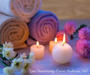 Spa ambiance with candles, towels, flowers on University Drive, Auburn, AL. Relaxing atmosphere for a rejuvenating experience.